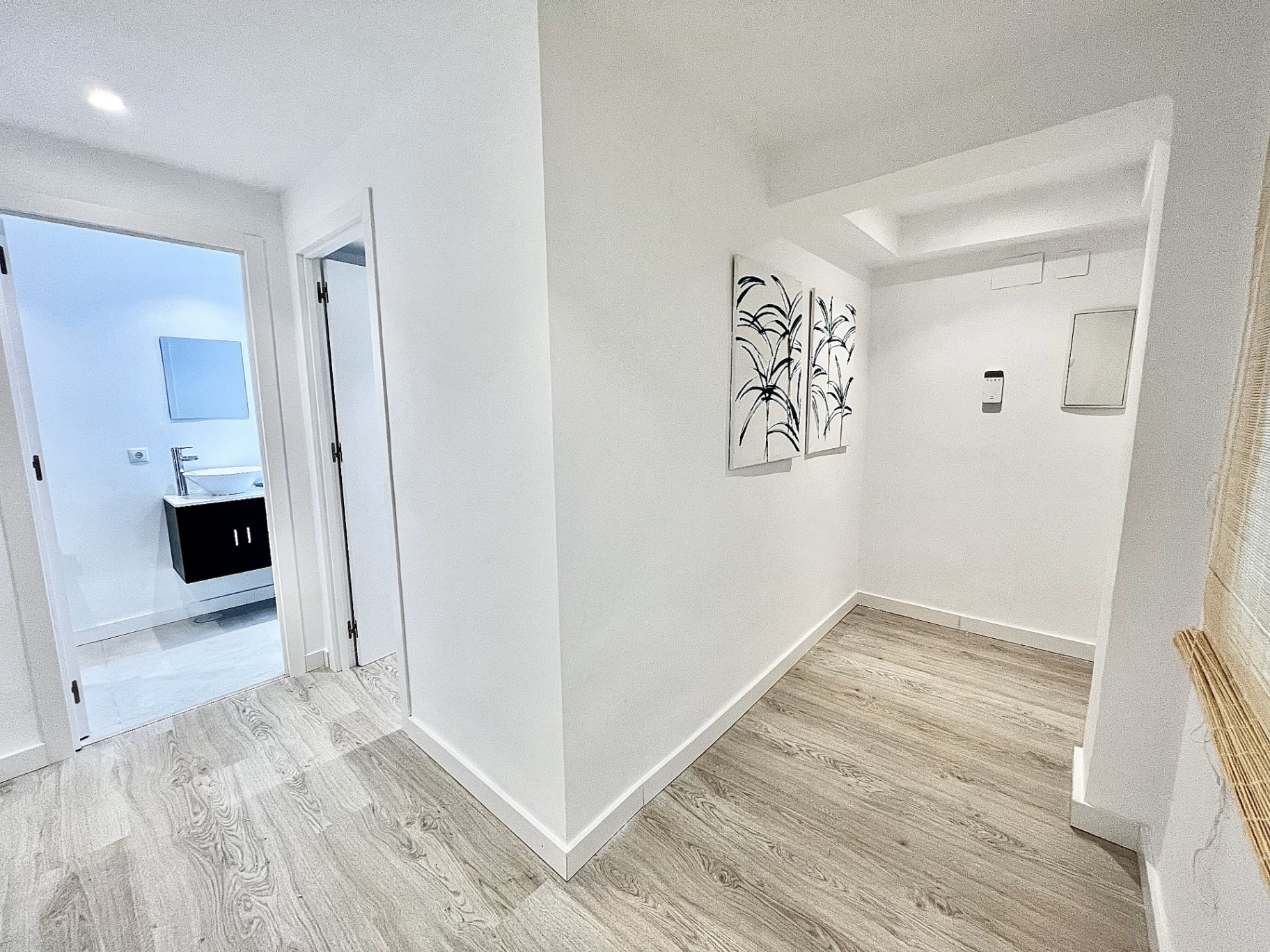 Distribuidor interior con nuevo pavimento, pintura y acceso a baños y dormitorios.