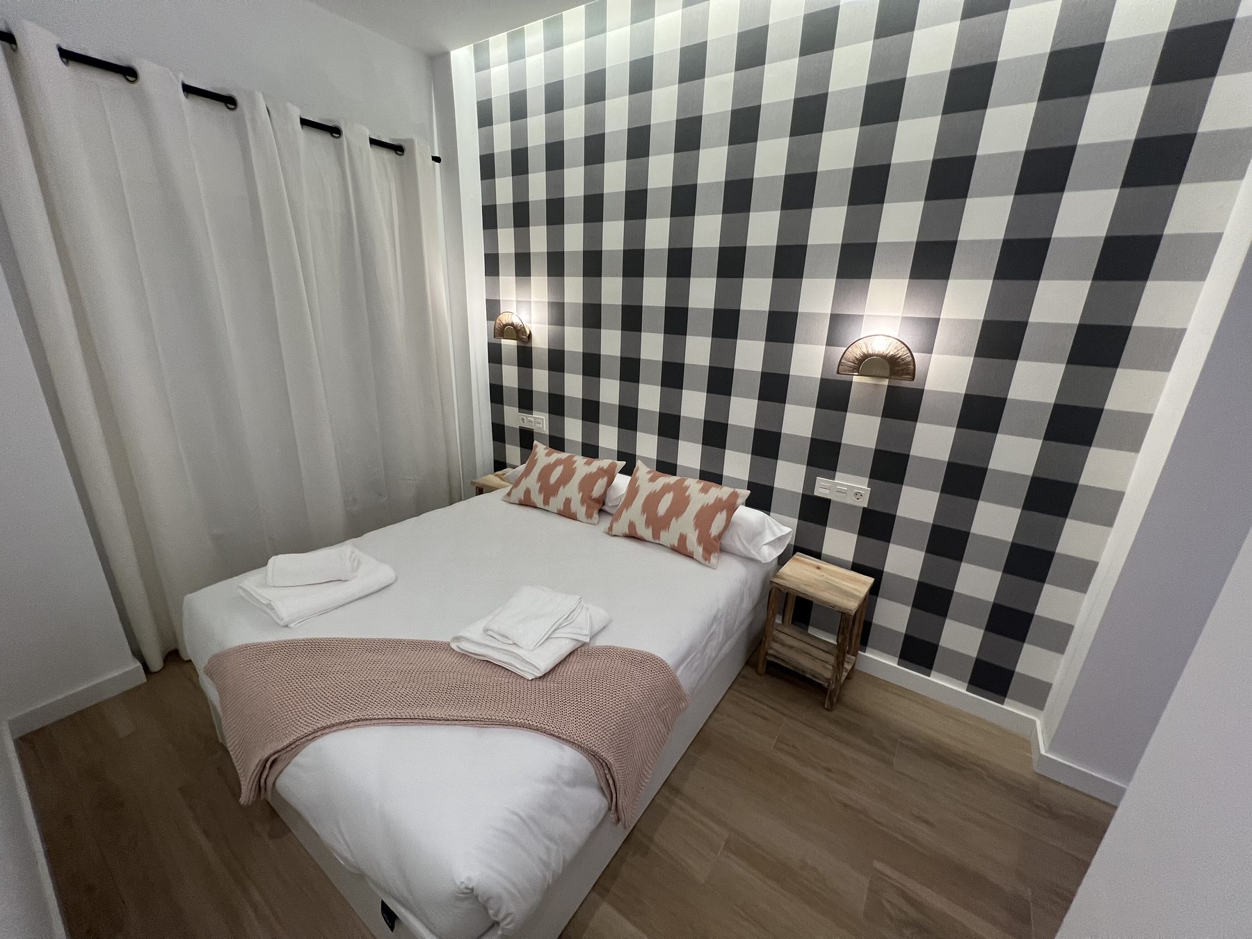 Dormitorio con cabecero decorativo y apliques a medida.