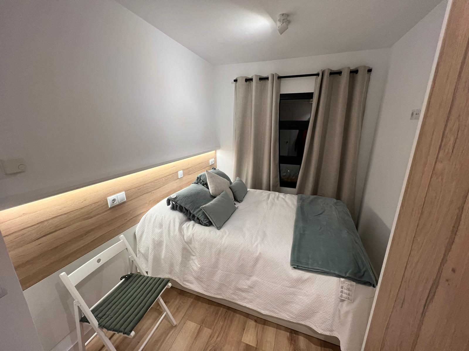 Dormitorio con cabecero iluminado a medida.