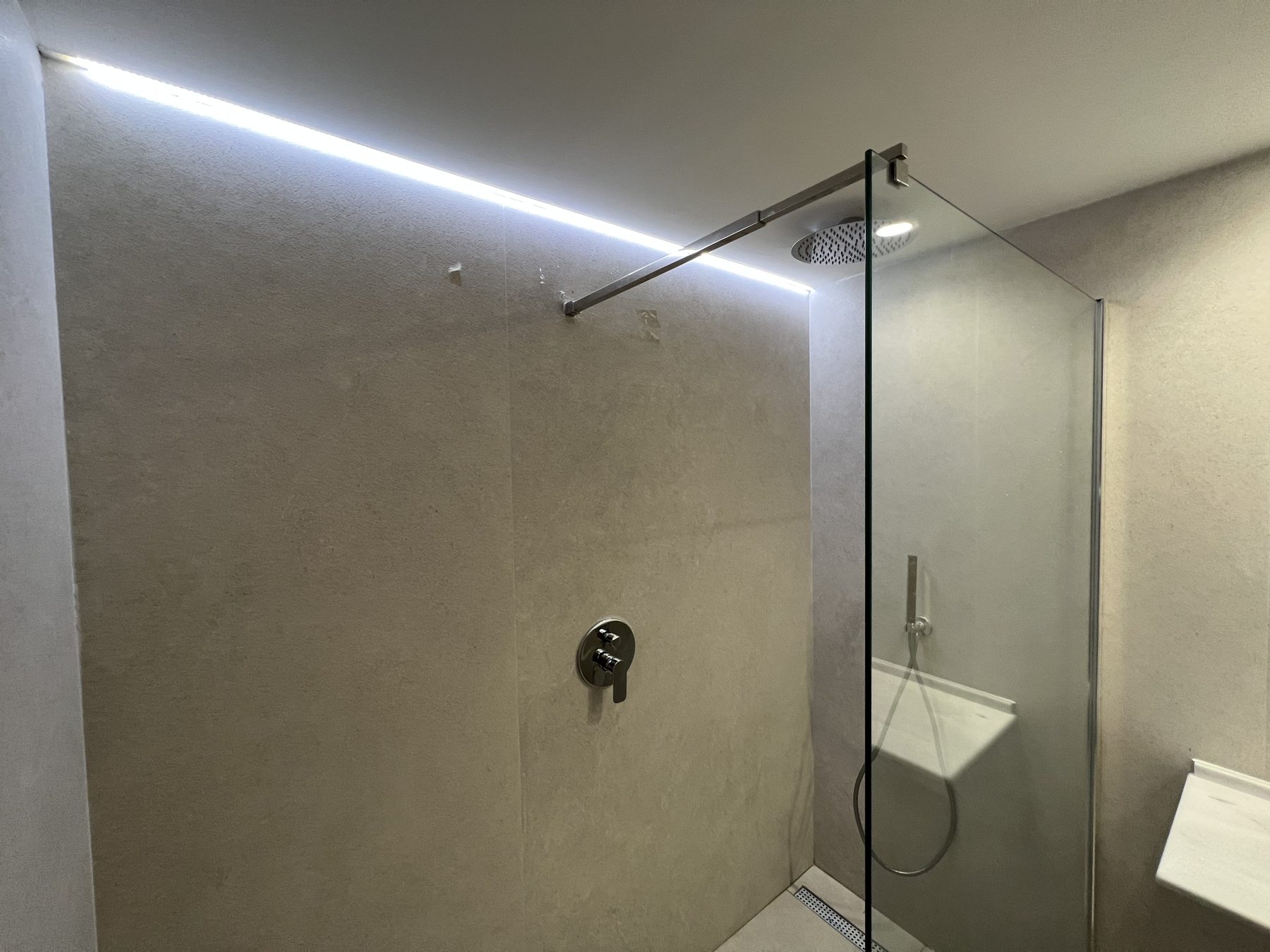 Ducha con iluminación LED perimetral y grifería empotrada.